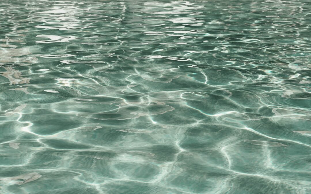 Close-up view of calm, rippling, cloudy pool water in a swimming pool, reflecting light in a pattern of shimmering lines and gentle waves.